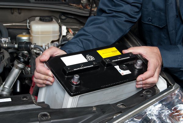 Auto mechanic replacing car battery A car mechanic replaces a battery.
